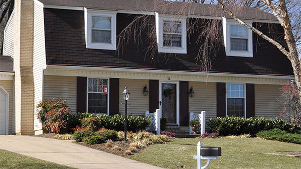 Home front with brown shingles.